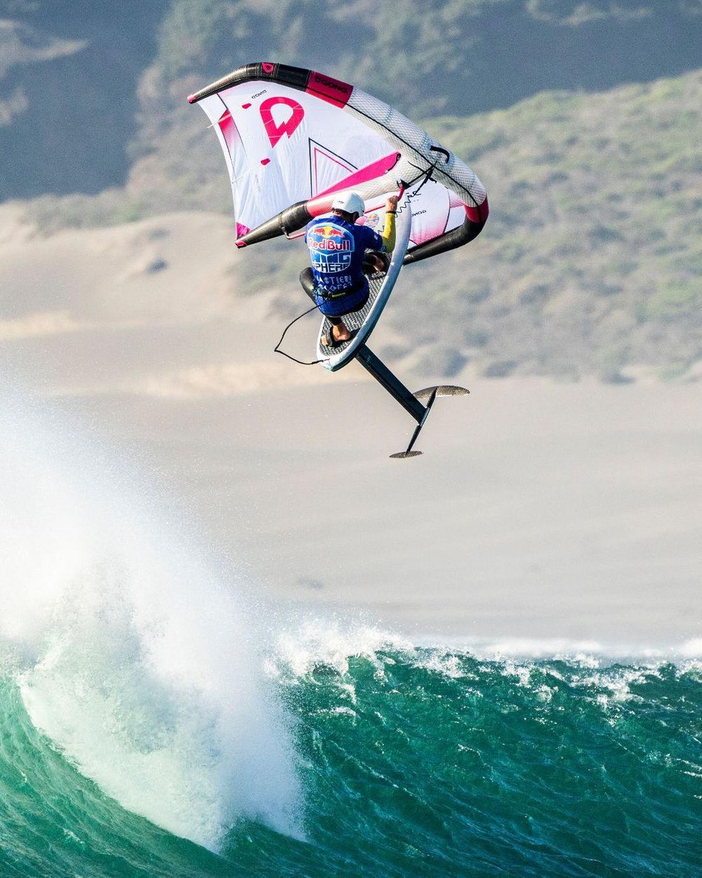 Wing foil en pleno salto sobre una ola