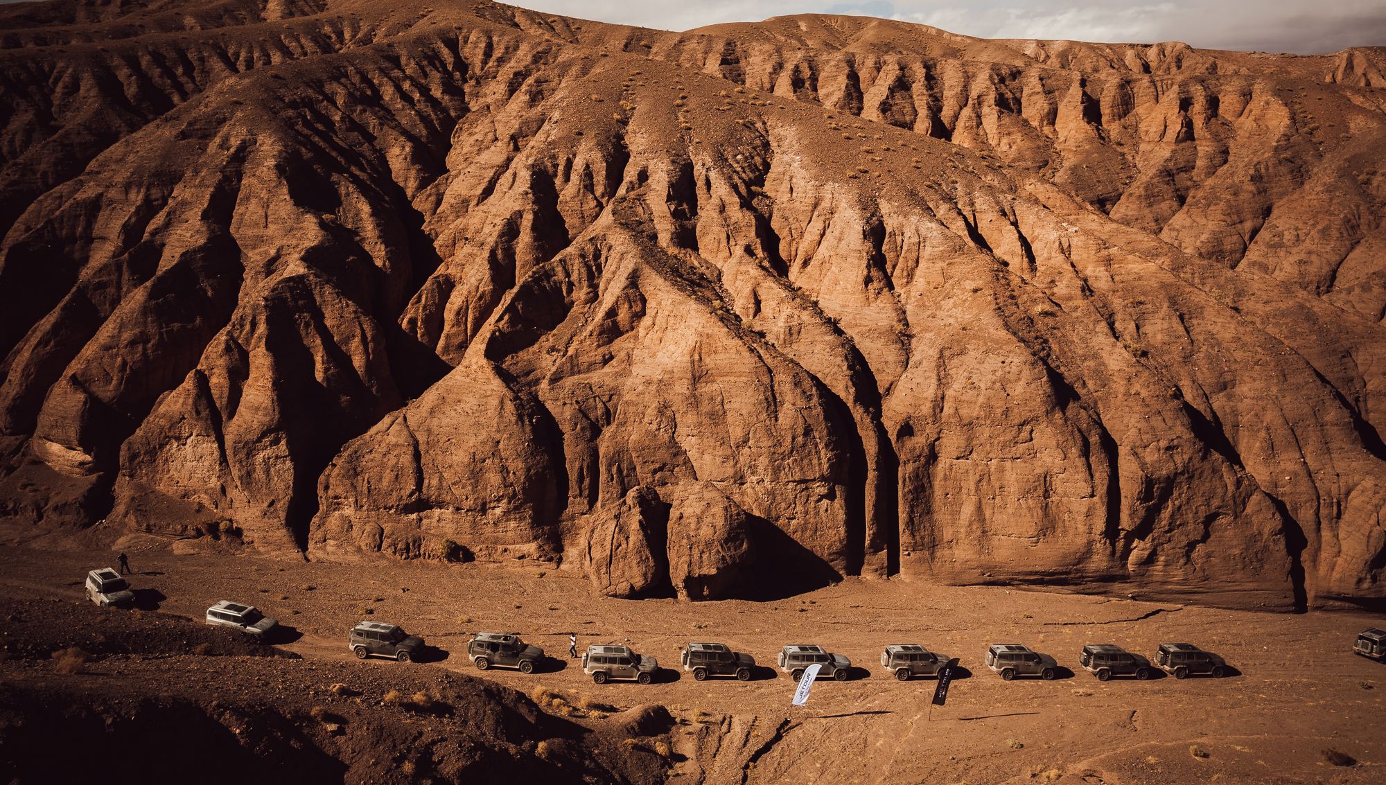 Caravana de vehículos 4x4 cruzando un cañón desértico