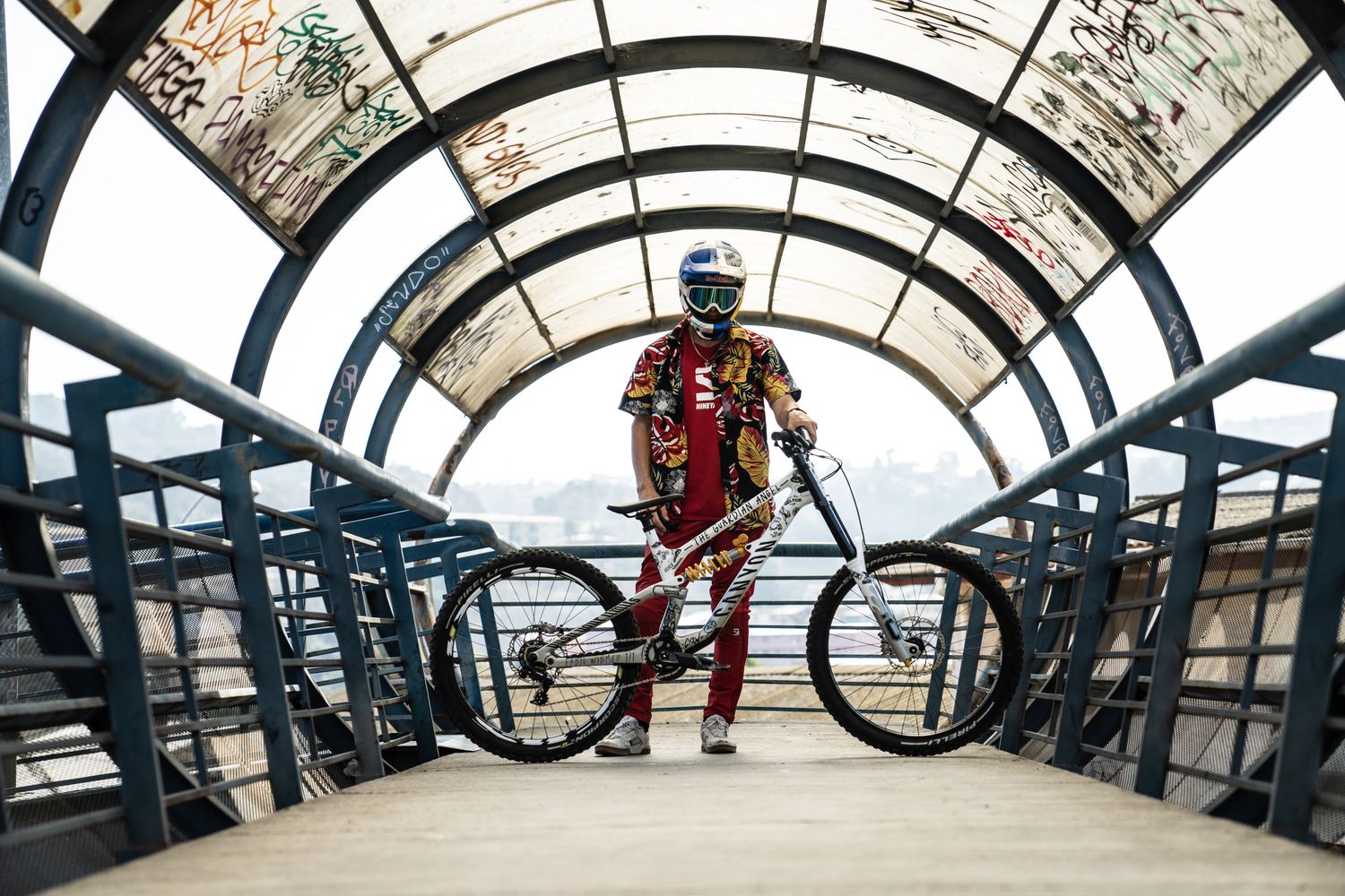 Ciclista con casco Red Bull y bicicleta en un túnel con grafitis